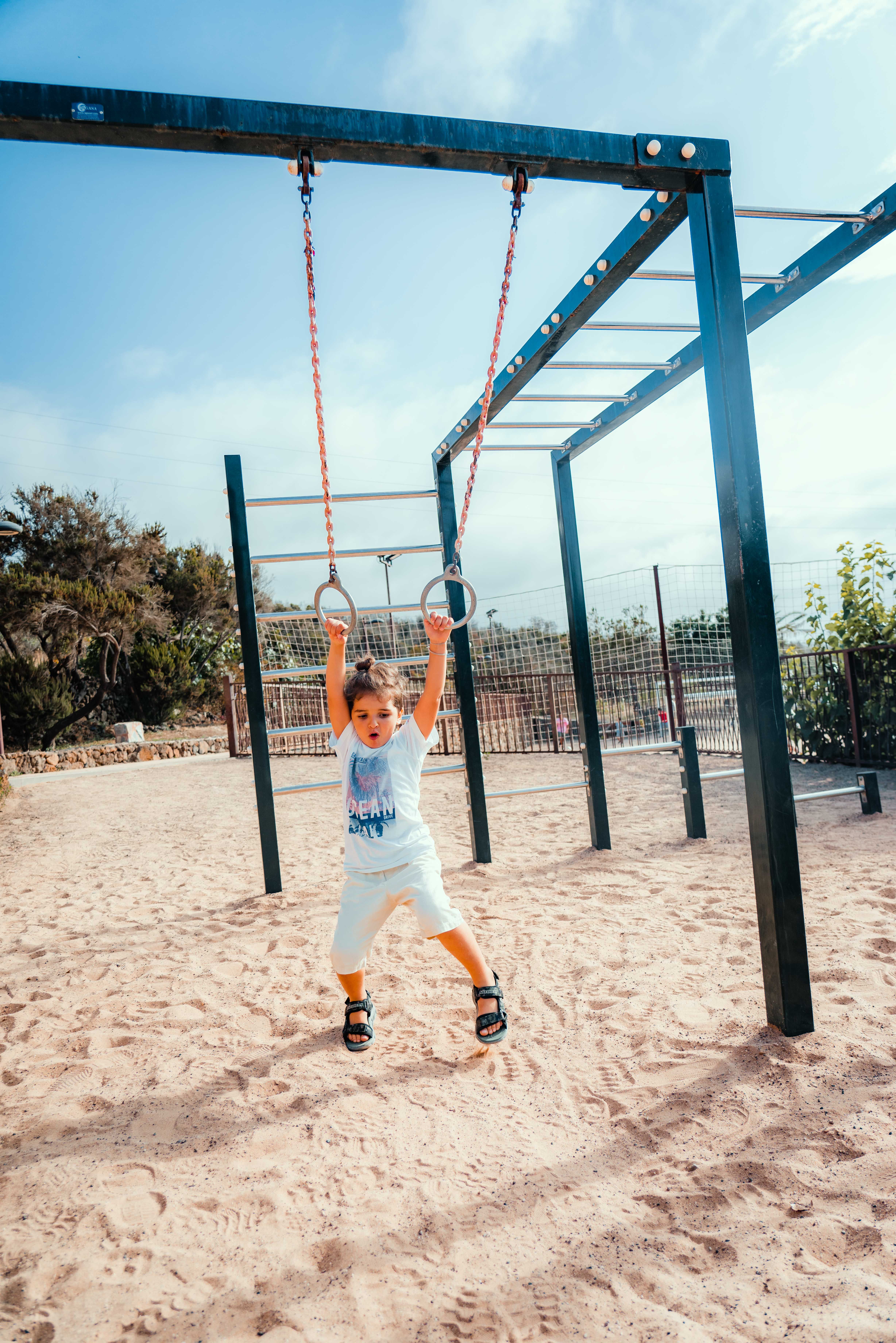 A Boy Swinging on Still Rings · Free Stock Photo