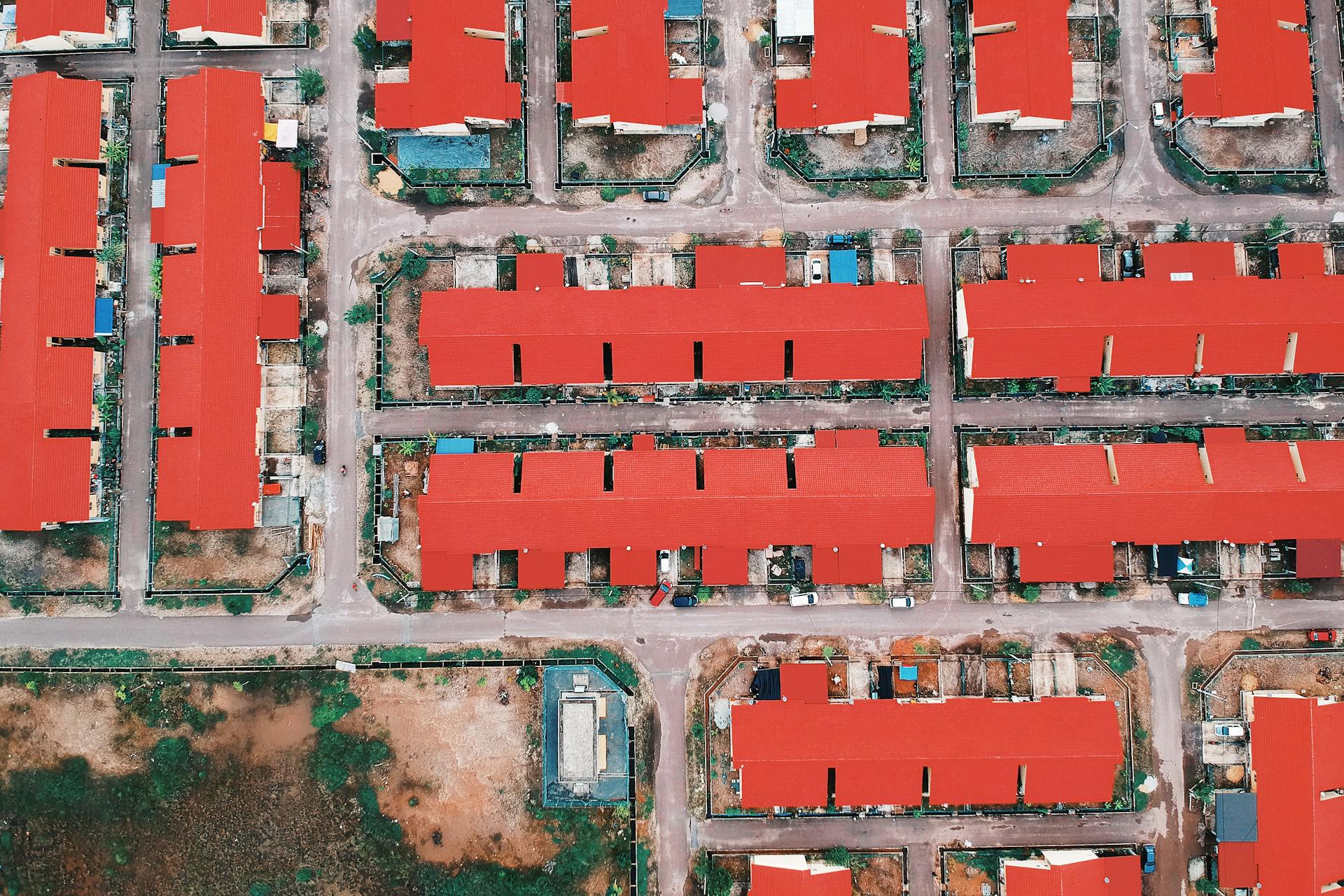 Aerial view showing red-roofed houses in a residential layout, captured from above.