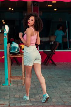 Stylish woman in summer outfit walking outdoors, exuding confidence and elegance.
