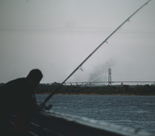 Blur Photo of Man Fishing on Sea