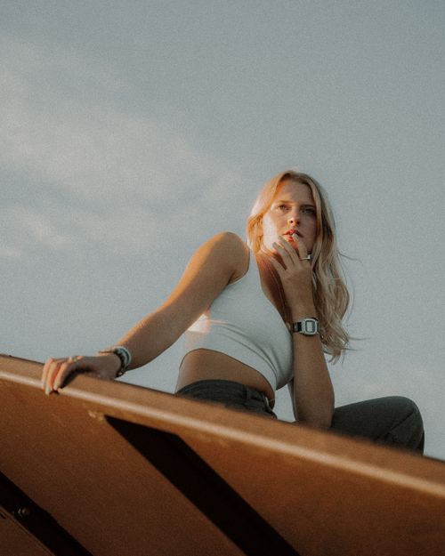 Free Blonde woman posing in fashionable attire outdoors with a thoughtful expression. Stock Photo