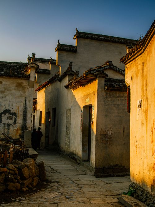 Free Sunlit narrow alley in a historic village showcasing traditional Asian architecture. Stock Photo