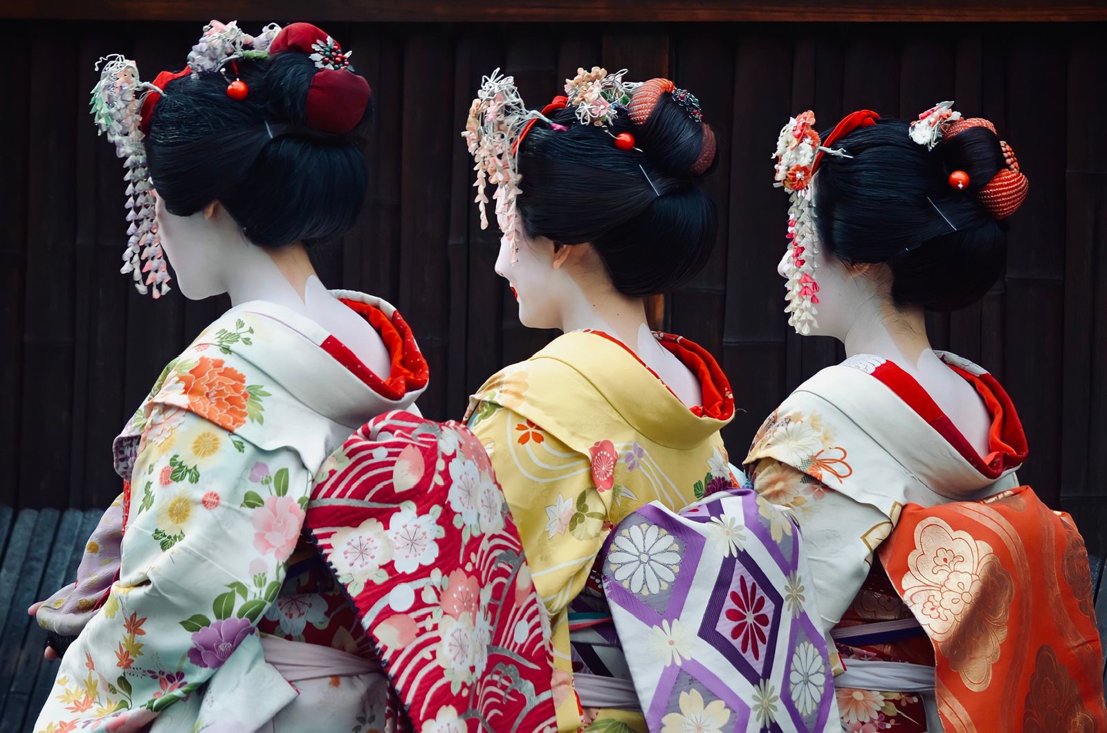 三位身穿花纹和服的女性背影，展现传统日式优雅