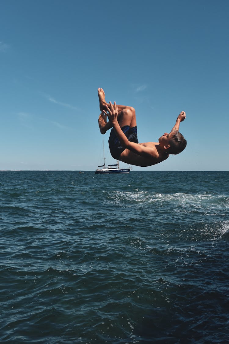 Boy On Mid Air Above Seawater 