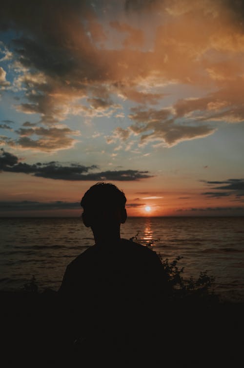 Free Silhouette Photography of Man Near Body of Water Stock Photo