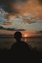 Silhouette Photography of Man Near Body of Water