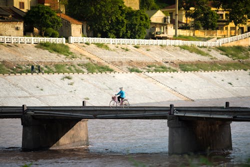 A Person Riding a Bike on the Concrete Bridge