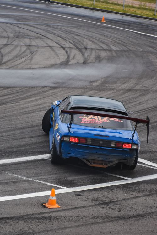 Free Blue car drifting on asphalt race track, captured in action from behind. Stock Photo