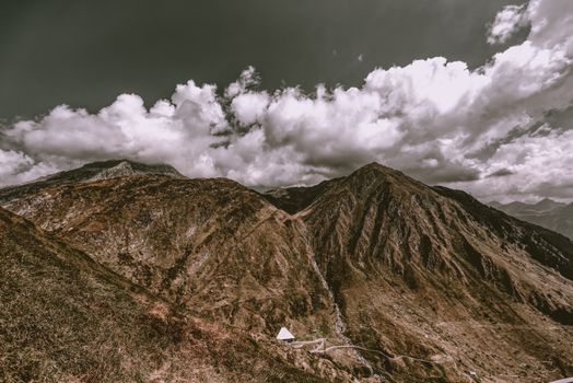 Scenic view of a mountain range with dramatic clouds over the peaks, showcasing natural beauty.