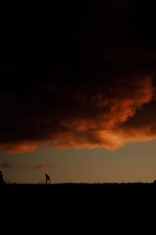 Dark Storm Cloud and a Man on the Horizon · Free Stock Photo