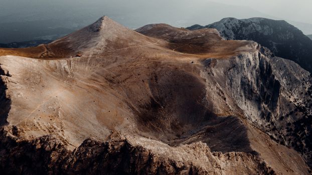 Stunning aerial photo of a barren mountain landscape under the soft light of sunset.