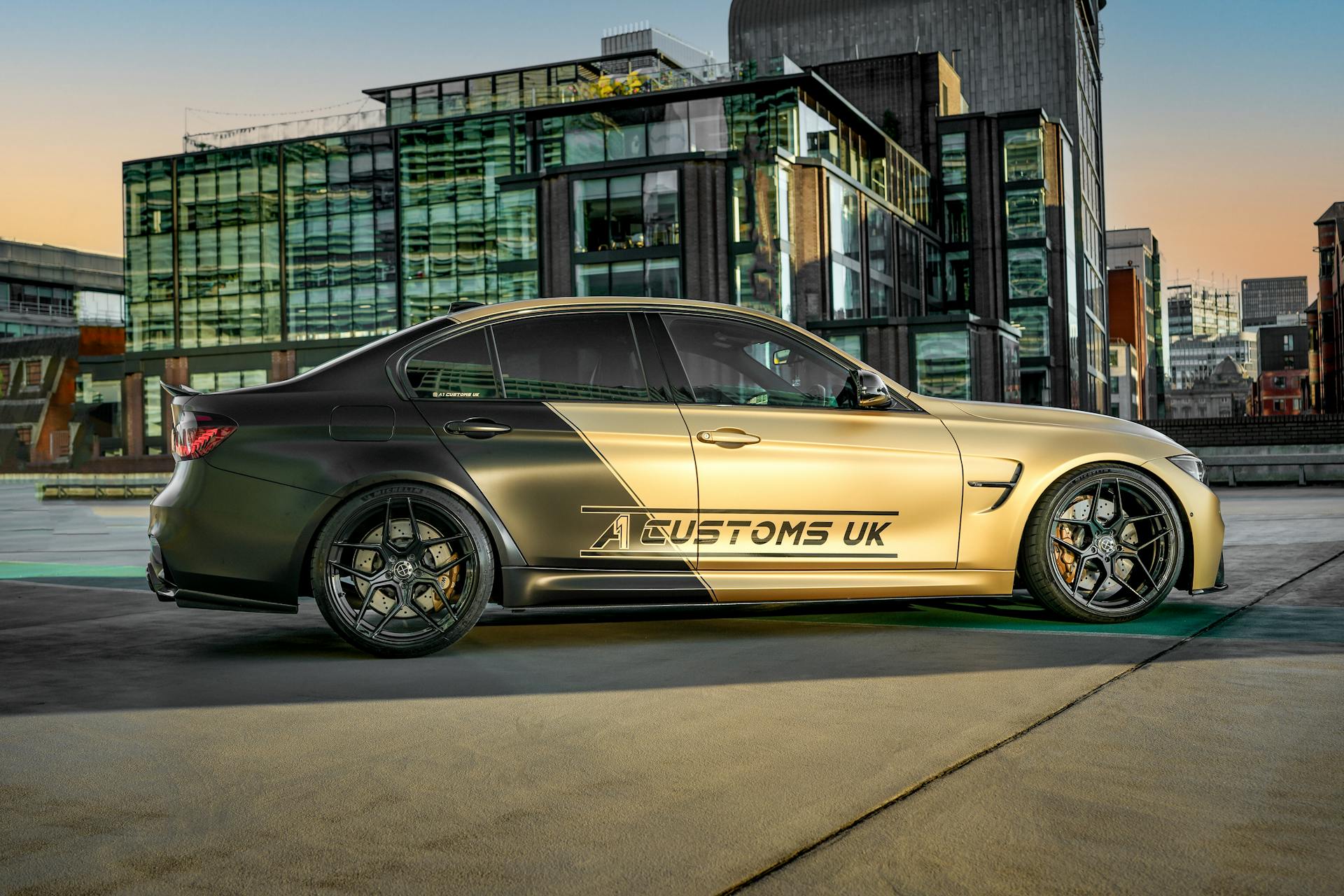 Sleek BMW M3 with custom decals in a modern urban setting, showcasing automotive design.