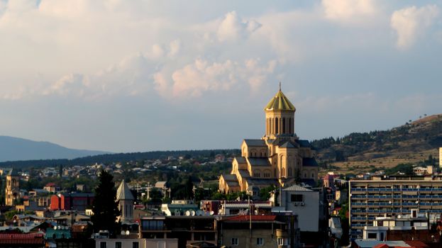 A picturesque cityscape featuring a prominent cathedral under a vast sky, capturing urban tranquility.