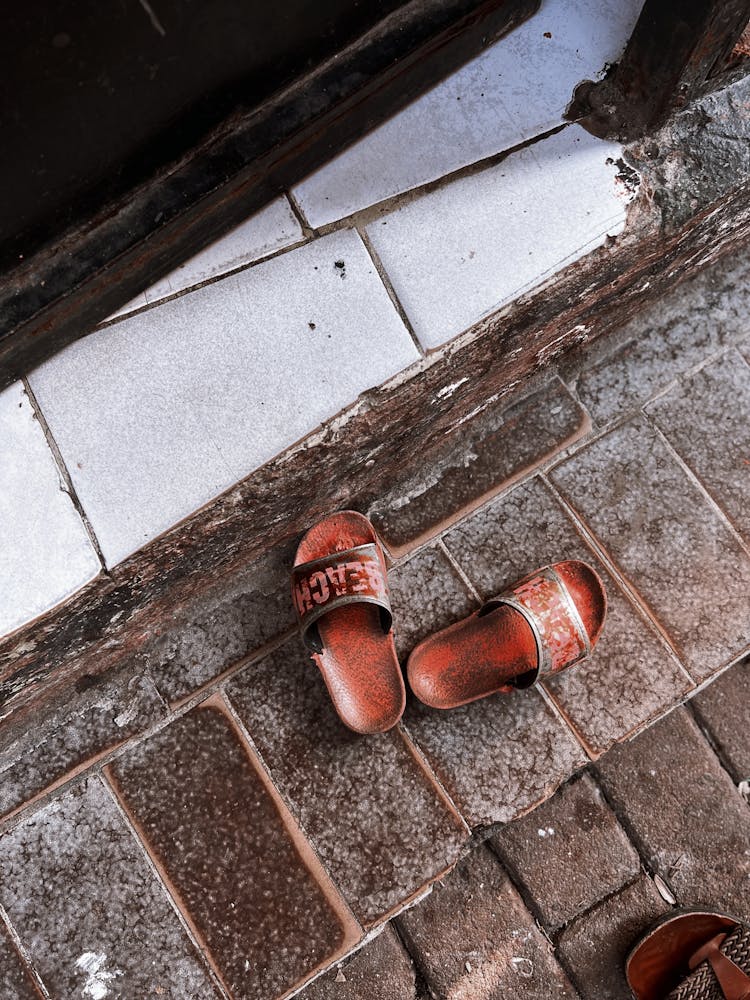 Worn Out Slippers On The Floor