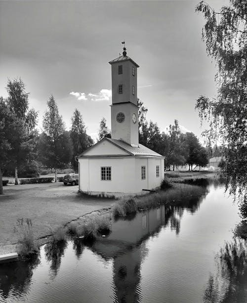 Grayscale Photo of a Church Building Beside the River 