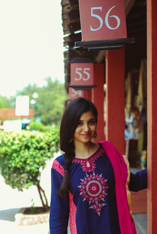 Smiling Woman Standing Beside Red Post