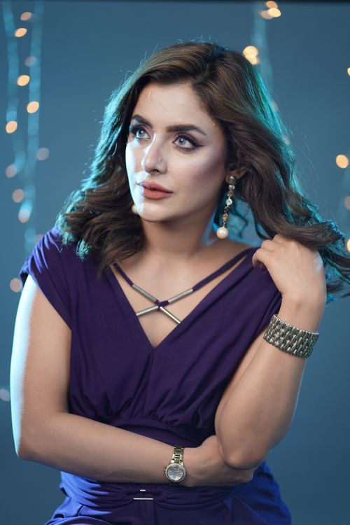 Free Sophisticated woman in purple dress posing gracefully against a bokeh light background. Stock Photo