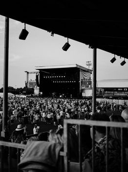 Black and white photo of a large crowd enjoying an outdoor concert.