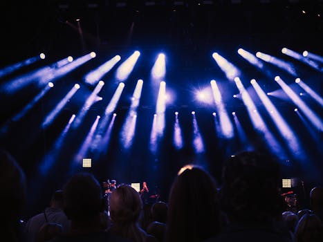 Lively crowd enjoying a concert with stunning stage lights and atmospheric ambiance.