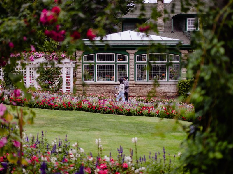 Victorian house surrounded by vibrant garden with couple walking by - neighborhood history for realtors