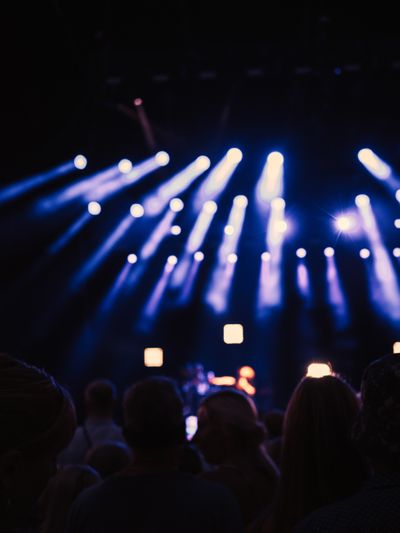Stage beams over a night crowd, photo by Lisa Fotios on Pexels