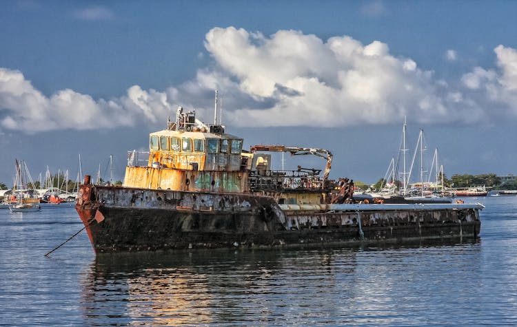 Rusty Abandoned Barge Floating On Water