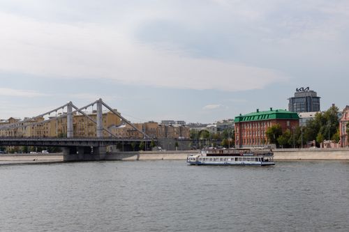 Free A picturesque view of the Moscow river with a bridge and ferry in the cityscape. Stock Photo