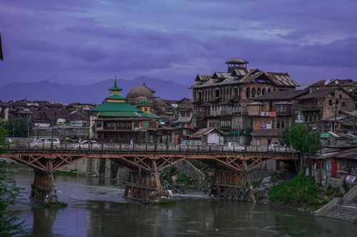 Free A picturesque view of a traditional wooden bridge and buildings in scenic Kashmir. Stock Photo