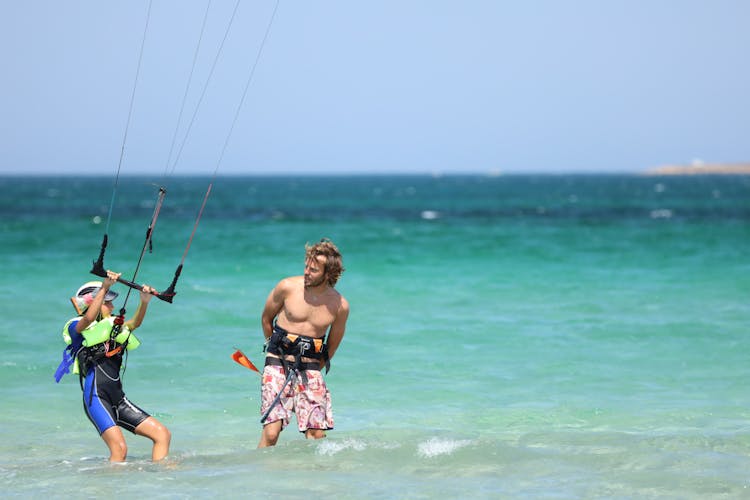 A Man Teaching A Woman How To Kite Surfing 