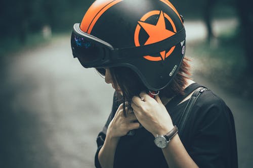 黑色和橙色的半臉頭盔上的女人