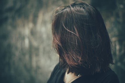 这幅艺术肖像以一位女性的头发和忧郁的色调为焦点