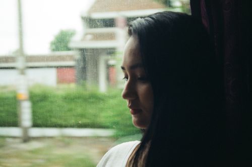 Free Serene portrait of a woman gazing thoughtfully out the window. Stock Photo