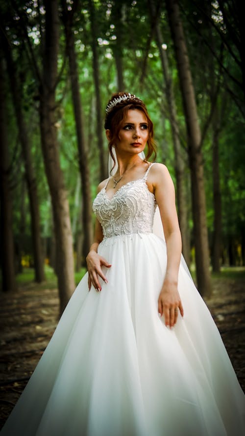 Woman in White Floral Dress Standing Near the Trees