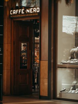 Café Nero with open wooden door showcasing interior ambiance and customers inside.