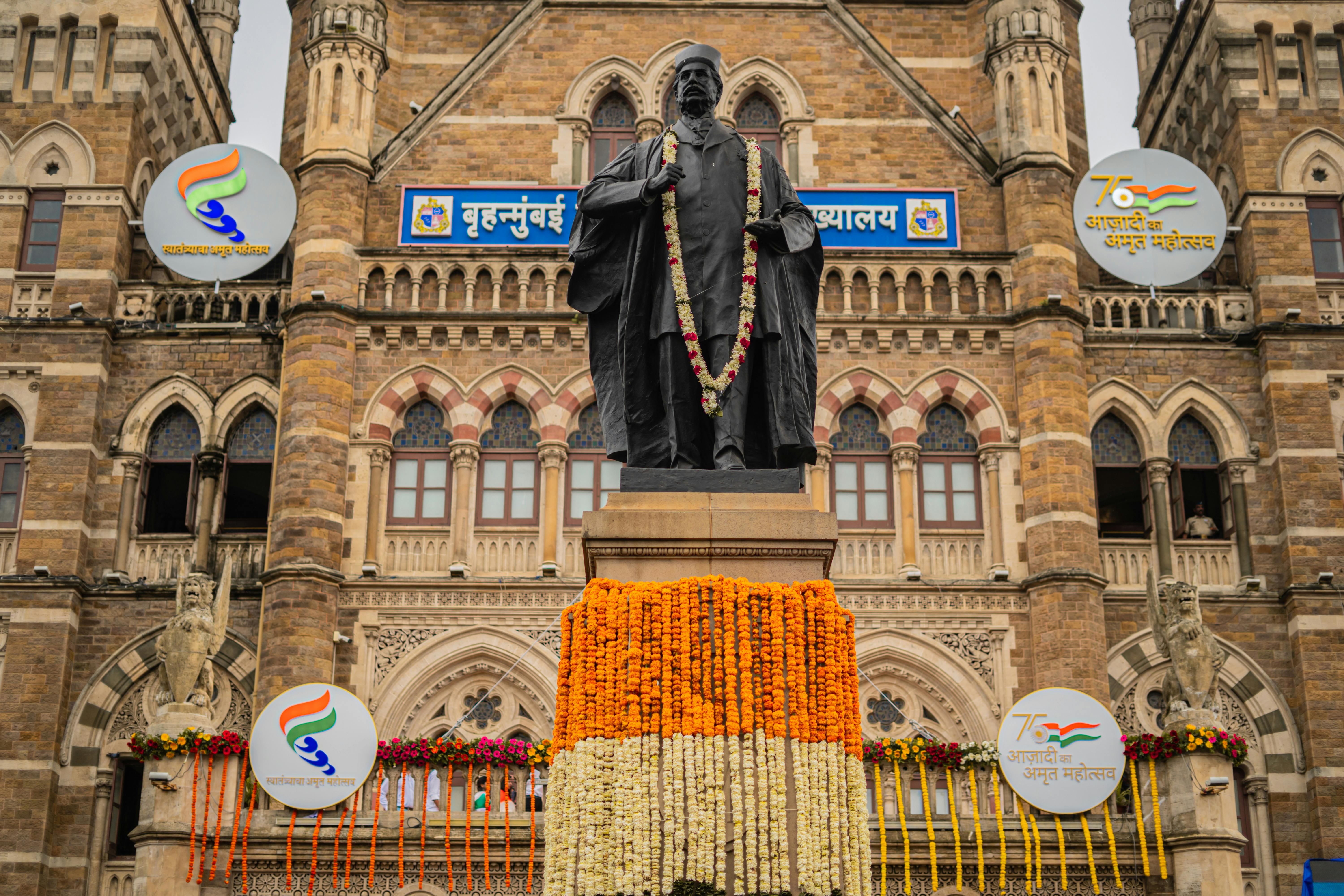 Decorated statue in front of iconic Mumbai edifice, exuding cultural heritage.