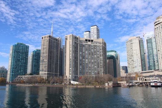 Toronto's urban skyline with modern skyscrapers reflecting on a calm body of water.