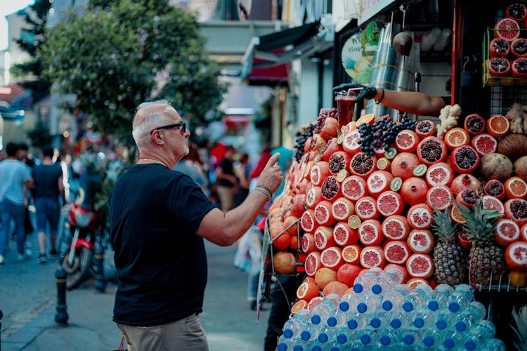 Man Picking Fruit In A Market Stall