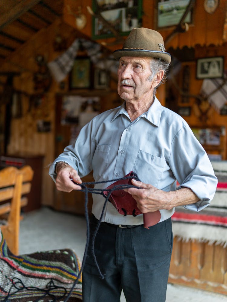 Old Man In Hat In Wooden House