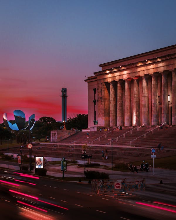 Car Lights on Road in Front of Museum