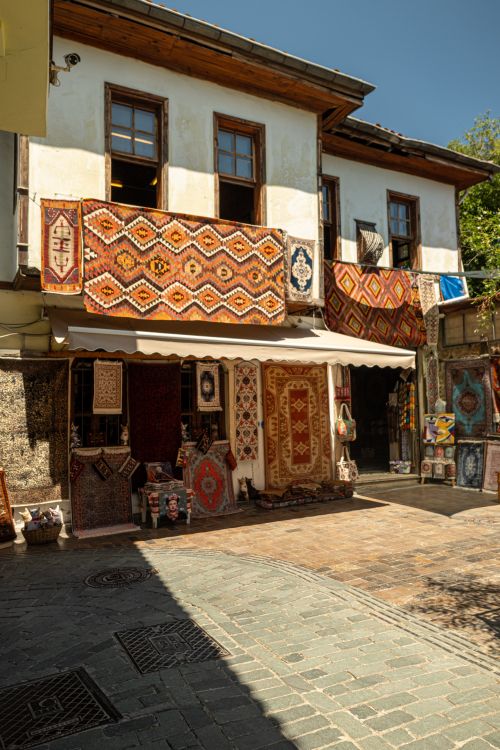 Free Explore a traditional rug shop with vibrant handmade carpets and a charming building facade. Stock Photo