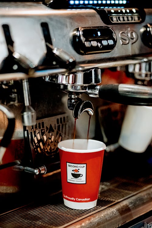 Coffee Flowing into a Disposable Cup from an Espresso Machine 