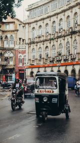An auto and motorcycles on a busy Mumbai street