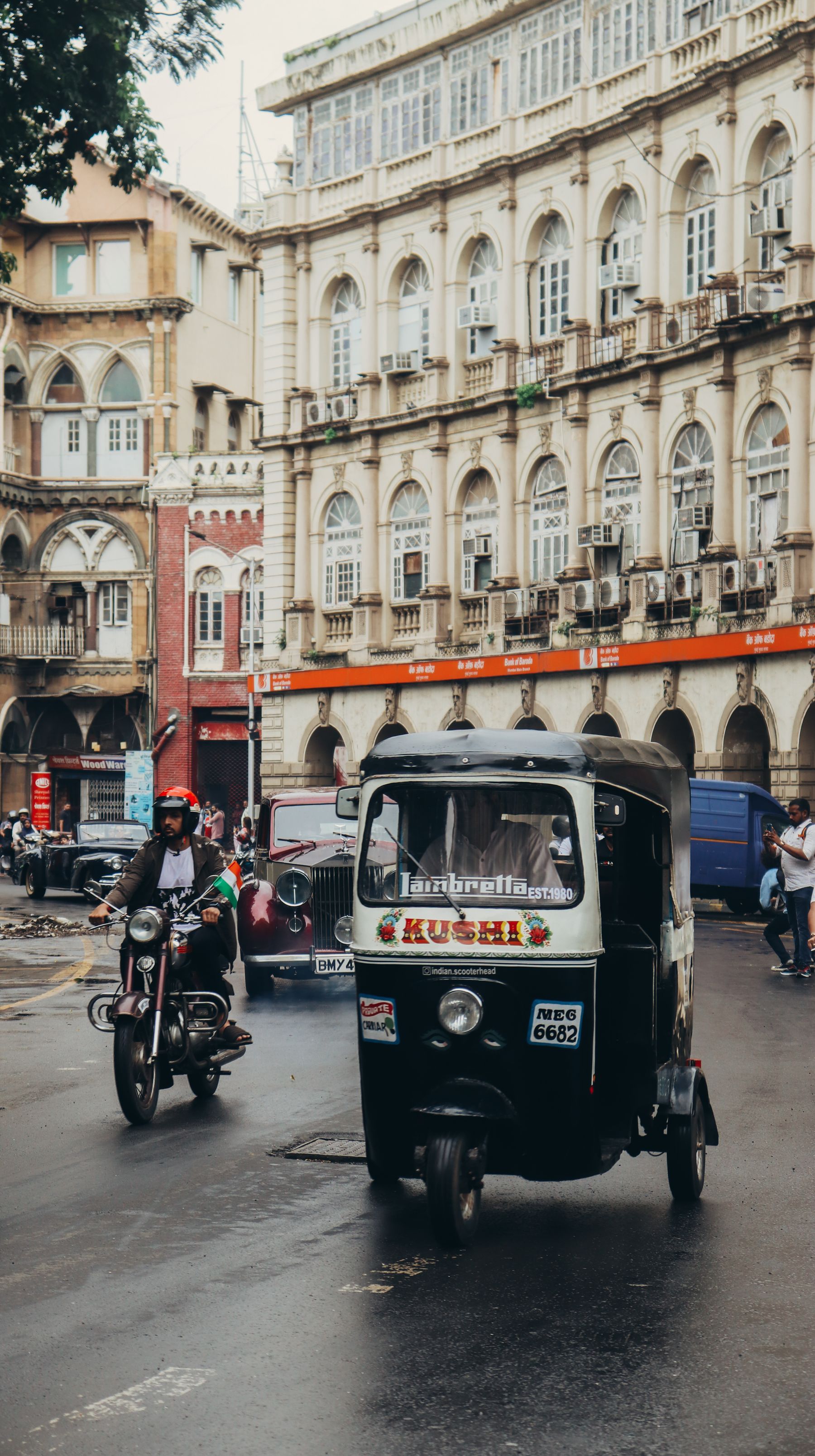 An auto and motorcycles on a busy Mumbai street