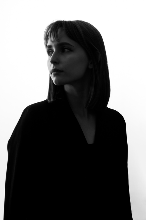 Free Artistic black and white portrait of a woman in a thoughtful pose, looking to the side. Stock Photo