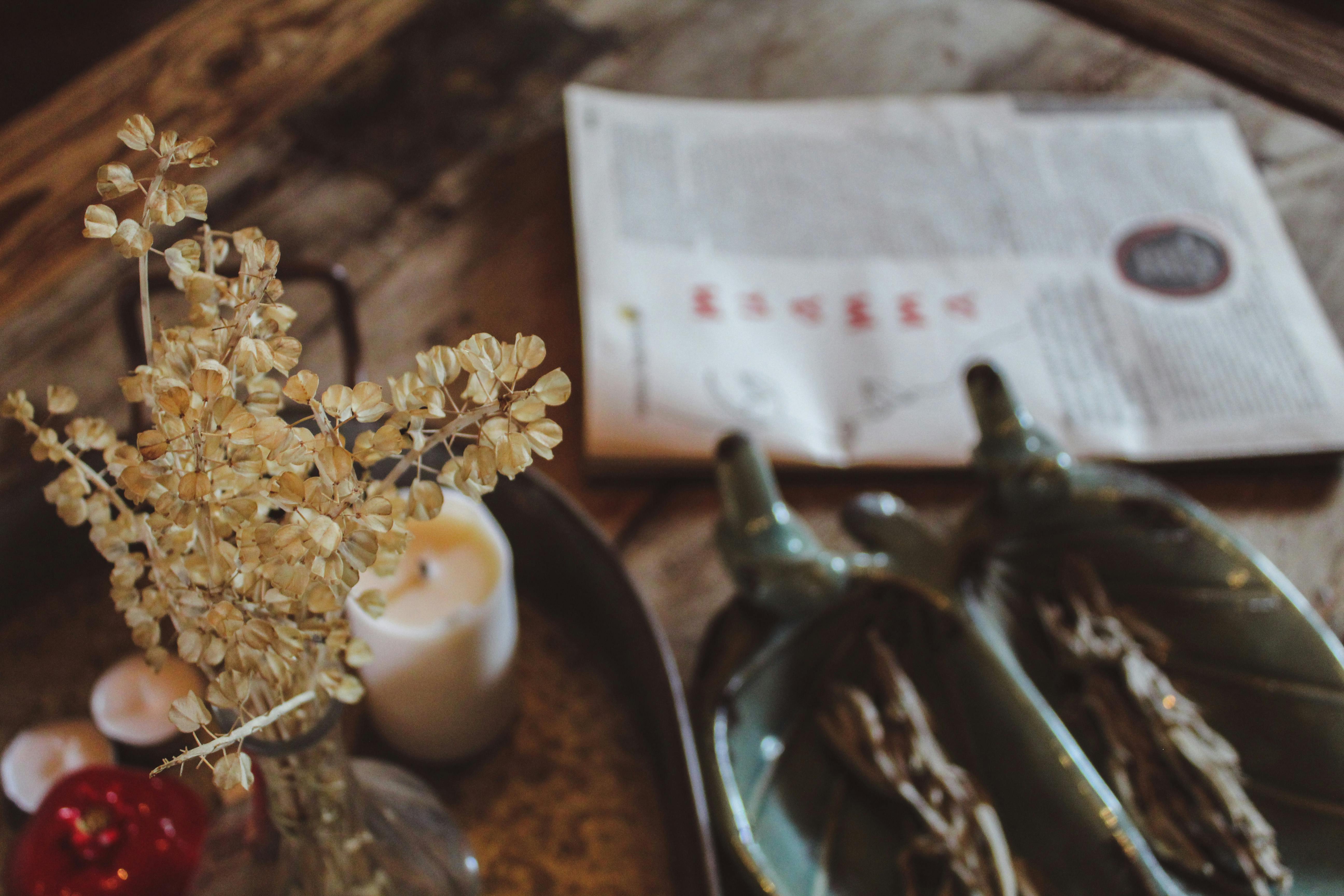 Warm autumn decor with dry flowers, candles, and rustic elements on a wooden table.
