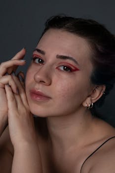 Studio portrait of a woman with dynamic red eyeshadow, showcasing beauty and self-expression.