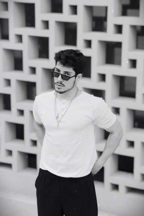 Free A stylish man in sunglasses poses against a unique geometric wall in Istanbul. Stock Photo