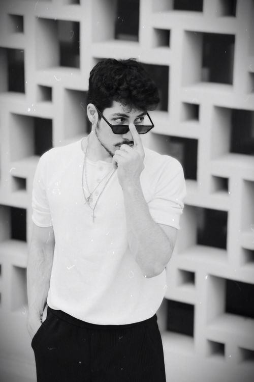 Free Portrait of a fashionable young man posing with sunglasses in a black and white composition. Stock Photo