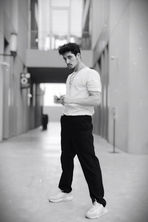 Young Man Standing in an Alley Between Buildings and Posing 