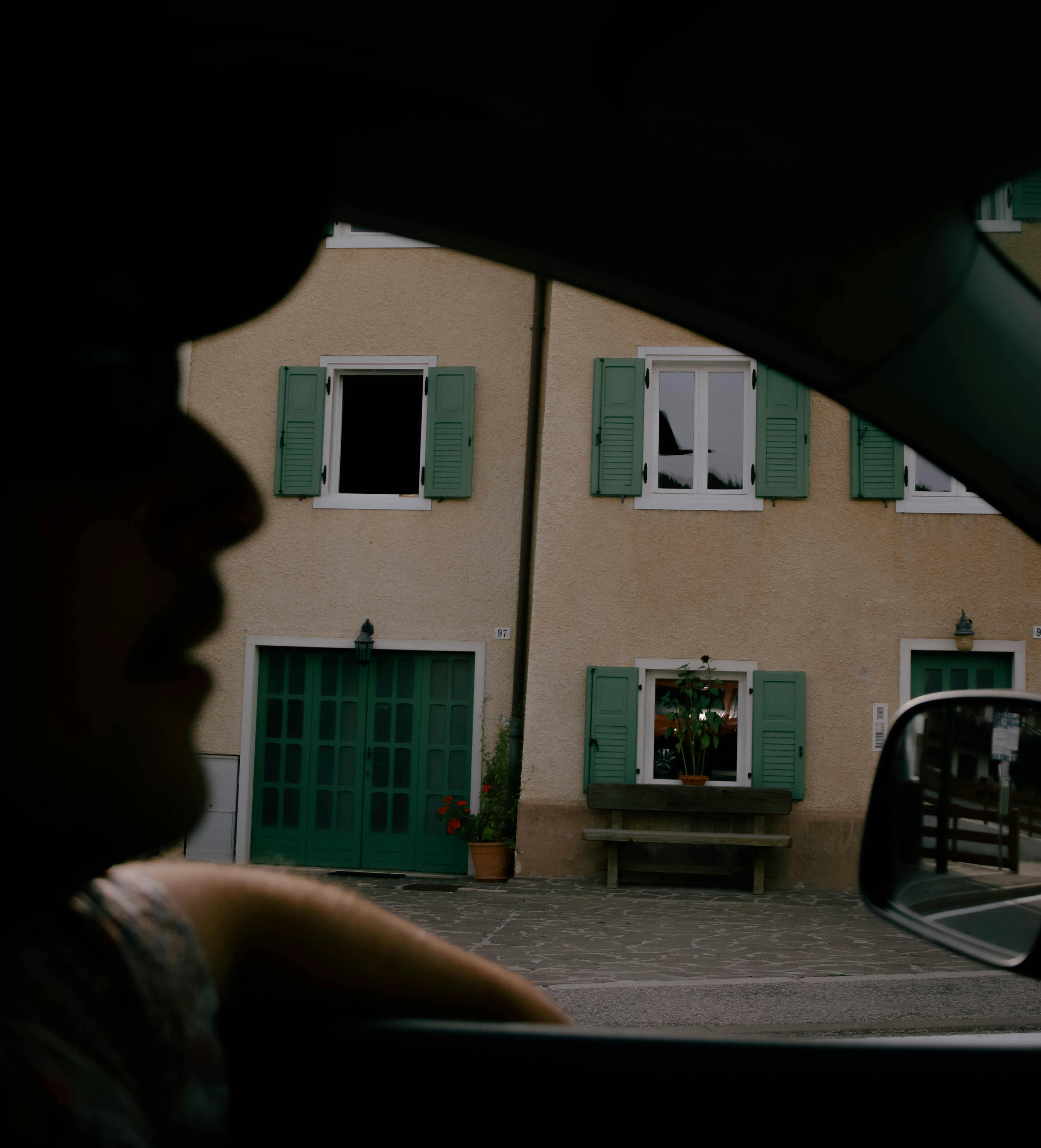 A unique view of Folgaria, Italy through a car window, capturing a building facade and silhouette.